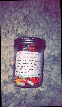 a jar filled with lots of candy sitting on top of a white sheet covered floor