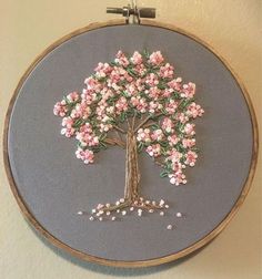 an embroidered tree with pink flowers on it