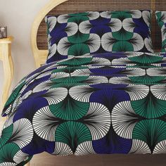 a bed with blue, green and white designs on it