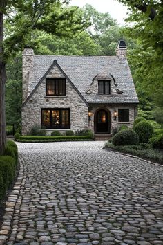 a stone house surrounded by trees and bushes