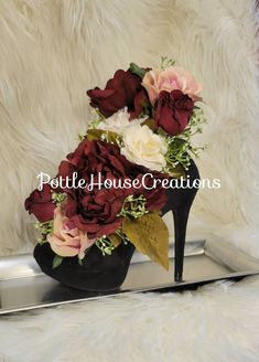 a black shoe with red and white flowers in it