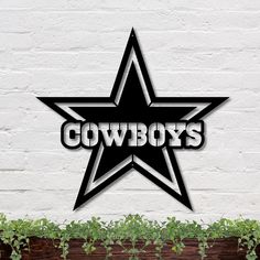 a large black and white star with the word cowboys on it in front of a brick wall