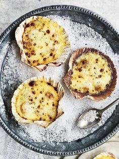 three baked muffins sitting on top of a metal plate with spoon and fork