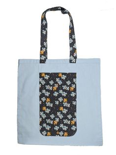 a blue and black bag with flowers on it is sitting in front of a white background