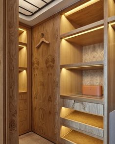 an empty closet with wooden shelves and lighting on the ceiling is lit by recessed lights