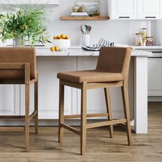 two brown chairs sitting next to each other in a kitchen