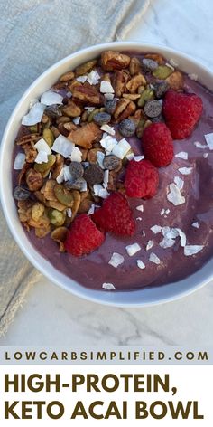 a bowl filled with granola, raspberries and nuts