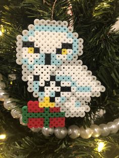 a christmas ornament made out of legos is hanging on a tree branch