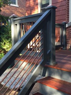 a wooden deck with metal railing and handrail