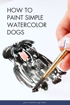 a person is holding a paint brush and painting watercolor dogs