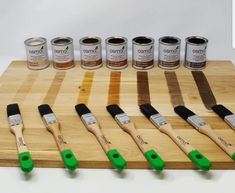 the paint brushes are lined up next to each other on a cutting board with different colors