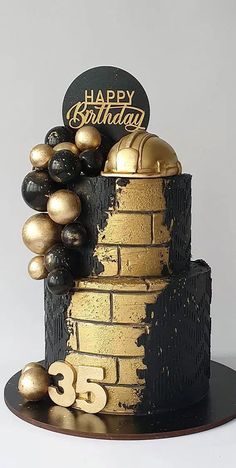 a black and gold birthday cake with balloons