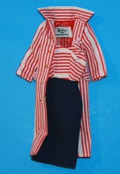 a red and white striped shirt is hanging on a blue wall with a black skirt