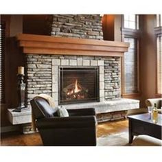 a living room filled with furniture and a fire place in front of a stone fireplace