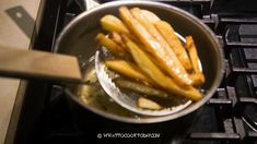 french fries are being cooked in a pot on the stove