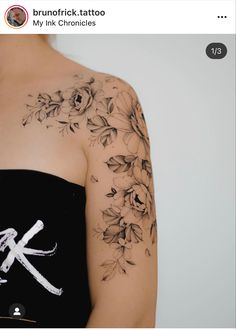 a woman's arm with flowers on it and the letter k in white ink