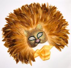 "The true king of the jungle! Crowned with layers of fluffy, golden rooster f feathers this mask is sure to impress!! Embellished with genuine swarovski crystals, ties with a 1.5\" satin ribbon and is lined with super soft, comfortable and easily wearable felt. NOTE: this mask takes at least a week to complete This mask will take center stage at any fete or gala, from Carnival in Brazil to New Year's in New York. Just be sure the event space has ceilings high enough to accommodate such a jaw-dro Extravagant Headpiece, Carnival In Brazil, Lion Mask, Lion's Mane, King Of The Jungle, Rooster Feathers, Lion Mane, Colorful Feathers, Masquerade Mask