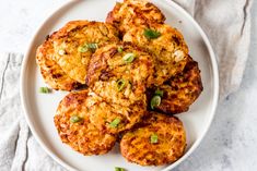 a white plate topped with crab cakes on top of a table