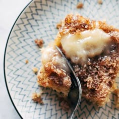 a piece of cake on a plate with a fork in it and some powdered sugar