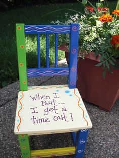 a wooden chair with the words when i get a time out written on it, next to potted plants