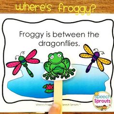 a frog is between the two dragonflies