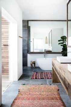 a bathroom with a rug on the floor next to a bathtub and sink in it