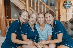 three women sitting on the floor posing for a photo in their matching blue and white pajamas