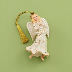 an angel ornament with a tassel hanging from it's side on a green background