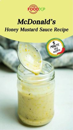 a jar filled with honey mustard sauce on top of a table