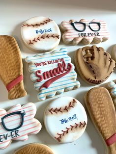 decorated cookies in the shape of baseballs, mitts and glasses are on display