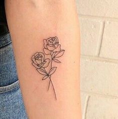 a woman's arm with three roses tattoo on the left side of her arm