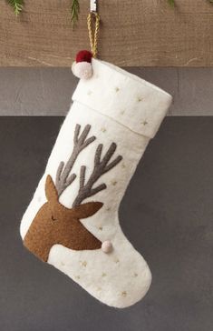 a christmas stocking hanging on a mantle with reindeer's head painted on it