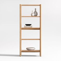 a wooden shelf with two vases and a bowl sitting on top of it, against a white background