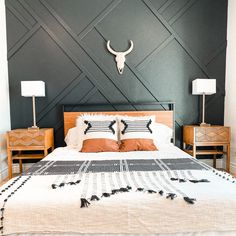 a bed with two nightstands and a cow skull on the wall