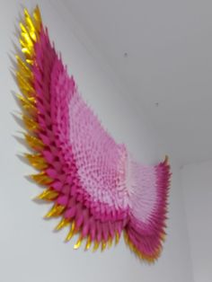 a pink and yellow object hanging on the wall