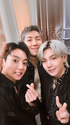 three young men posing for the camera with their thumbs up