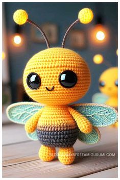 a small crocheted toy with big eyes and a bee on it's back