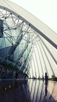 a large building that has some kind of structure on it's side and is reflecting in the water