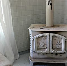 an old fashioned stove with two clocks on it's front and back sides, sitting in a corner