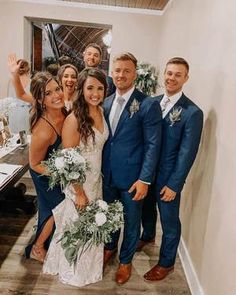 a group of people standing next to each other in front of a table with flowers