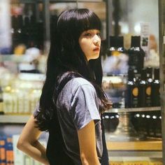 a young woman standing in front of a store window with her hands on her hips