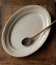 a wooden spoon sitting on top of a white plate