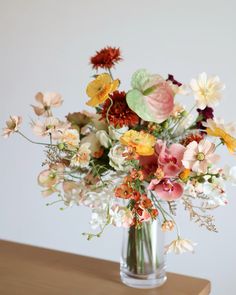 a vase filled with lots of different colored flowers