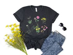 "Flower t-shirt, Gift for her, Women trendy tshirt, Spring concept, Wild meadow flower nature tee, Floral Tee, Gardener Botanical Shirt Our Unisex T-shirts are High Quality, SUPER soft and SUPER comfy. They made of 100% Cotton. Heather tees are a soft cotton-poly blend. We use BELLA+CANVAS for our T-shirts! FABRICATION * Solid Colors: 100% Ringspun Cotton * Heather Colors: 52% cotton, 48% polyester * Runs true to size SIZING This style is a unisex t-shirt. If you are unsure about the size you sh Wild Meadow, Nature Tees, Botanical Shirt, Meadow Flowers, Flower Nature, Floral Tee, Flower Shirt, Trendy Tshirts, Floral Shirt