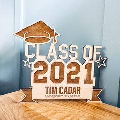 a wooden sign that says class of 2012 with a graduation cap on it and stars