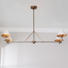 a chandelier hanging from the ceiling with three lamps on each side and two shades off