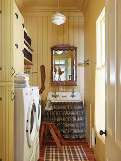 a washer and dryer in a small room next to a sink with a mirror on the wall