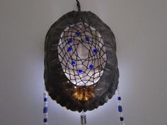 a decorative item hanging on the wall with beads and glass bead around it's edges