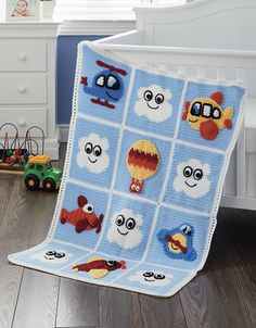 a crocheted blanket with many different faces on it in a child's bedroom