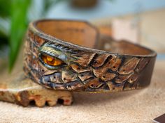 Genuine leather bracelet decorated with Baltic amber for a unique woman. This unique bracelet was made entirely by hand from a single piece of thick cowhide. dimensions: - thickness 4-5 mm - width at the widest point 3.8 cm - max inner circumference of the fastened bracelet 18.5 cm - fits wrist up to 17 cm in circumference This unique bracelet will be the best gift for your beloved woman. Leather Bangle Bracelet, Adjustable Unique Leather Bracelet, Adjustable Leather Cuff Bracelet, Adjustable Hand Tooled Leather Bracelet, Hand Tooled Brown Leather Bracelets, Brown Leather Hand-tooled Bracelets, Unique Leather Bracelet For Gift, Handmade Brown Leather Bracelet Adjustable Fit, Unique Adjustable Leather Bangle Bracelet